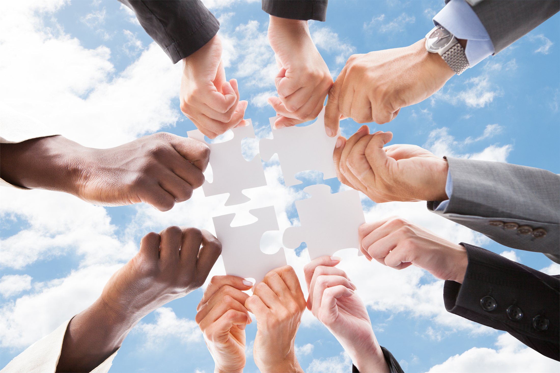 Colleagues joining puzzle pieces together